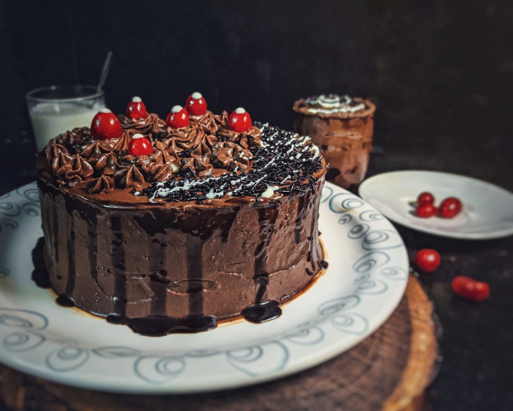 A delicious cake with chocolate frosting and cherry on top.
Captured by- @umesh.sonii (insta)